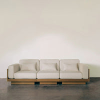 Cream-colored sofa with smooth fabric and natural wood base, creating a minimalist and modern look.