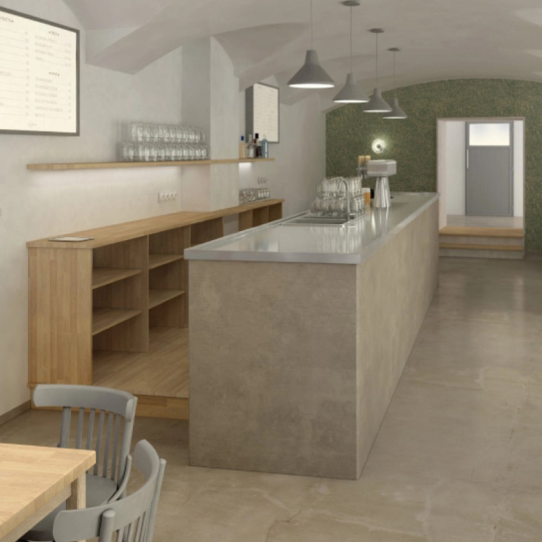 Modern café interior featuring a concrete bar, wood shelves, and a muted green accent wall in a minimalist design.