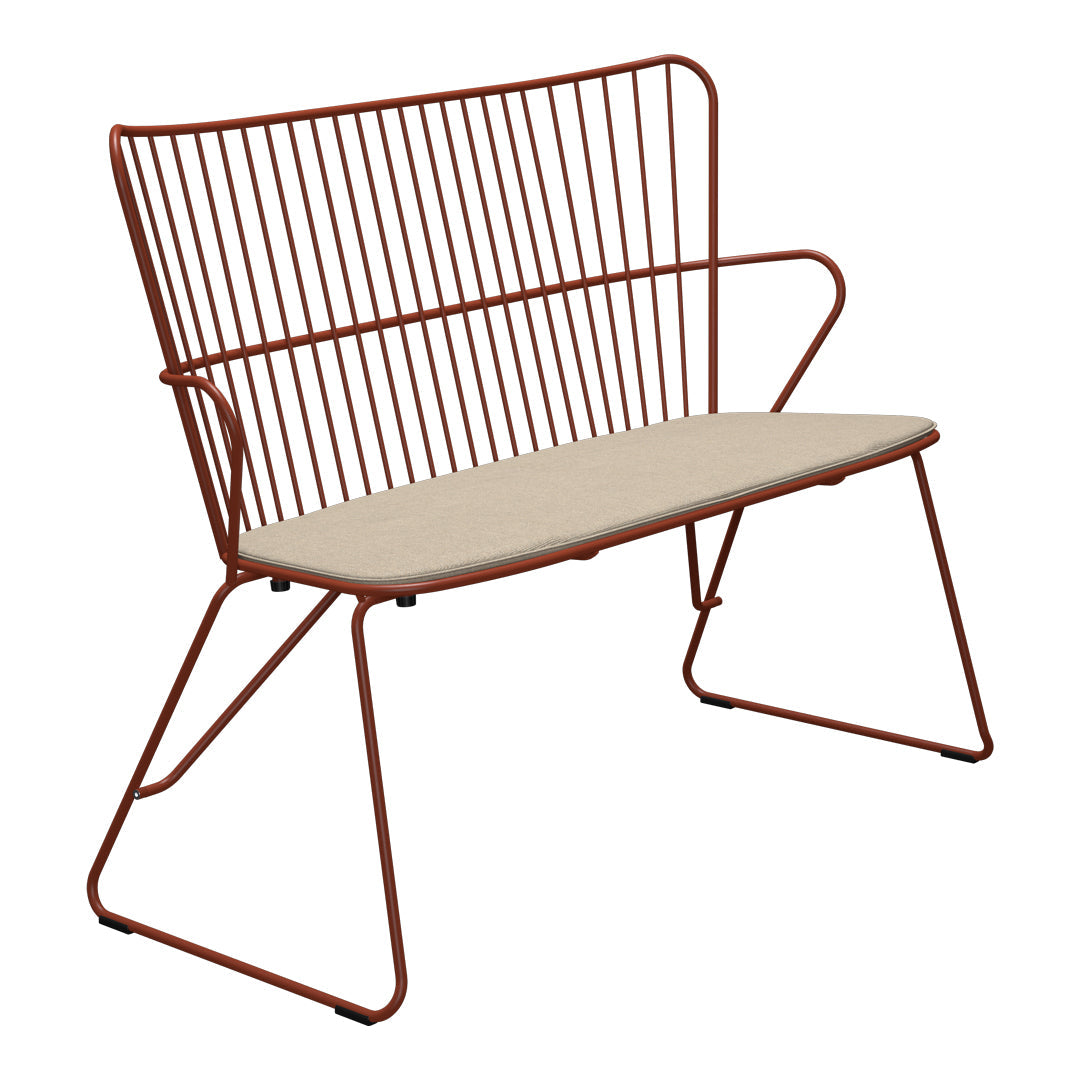 Rust-colored metal bench with a minimalist design and cream-colored cushion for added comfort.