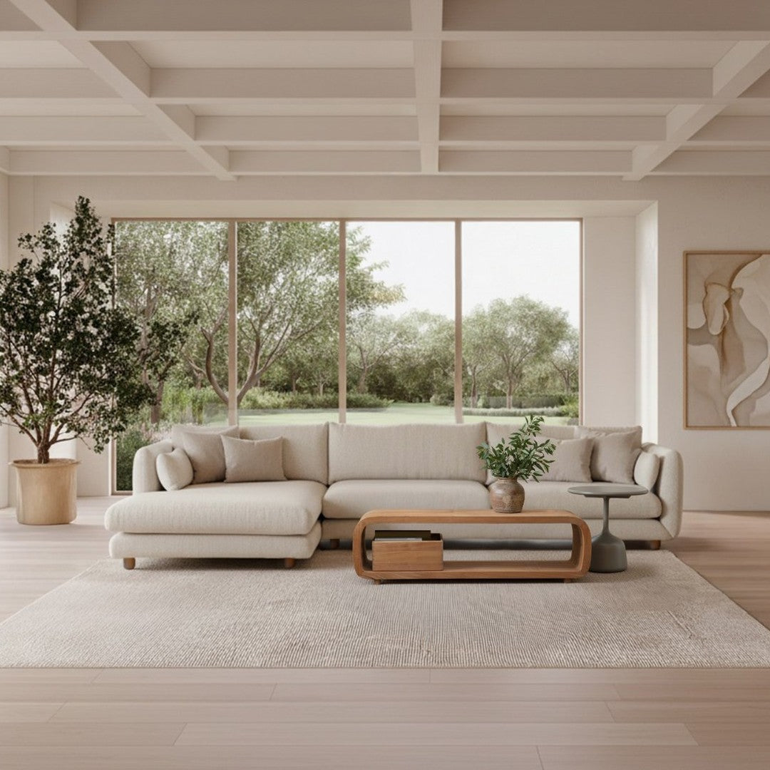 Light beige sectional sofa with soft, textured fabric, paired with a wooden coffee table and neutral patterned rug.