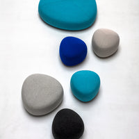 Colorful assorted stones in turquoise, blue, gray, and black with smooth, rounded shapes. Perfect for decorative accents.