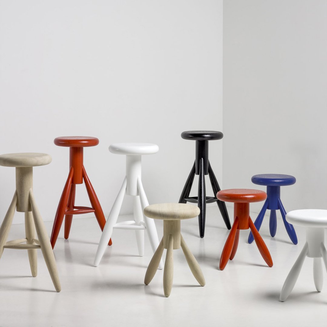Colorful modern stools in vibrant shades of orange, red, blue, black, white, and beige with unique patterns.