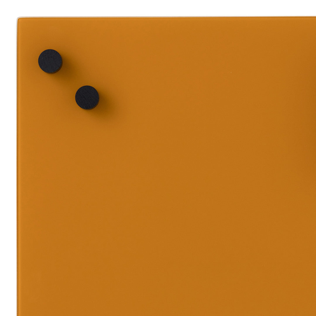 Orange surface with two black decorative knobs, featuring a smooth, modern design.