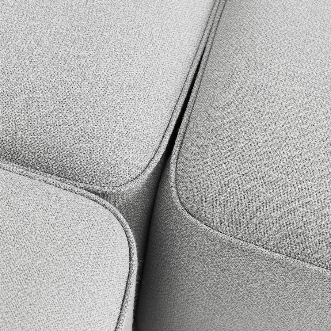 Soft light gray textured fabric with seamless curves and subtle detailing, ideal for modern furniture design.
