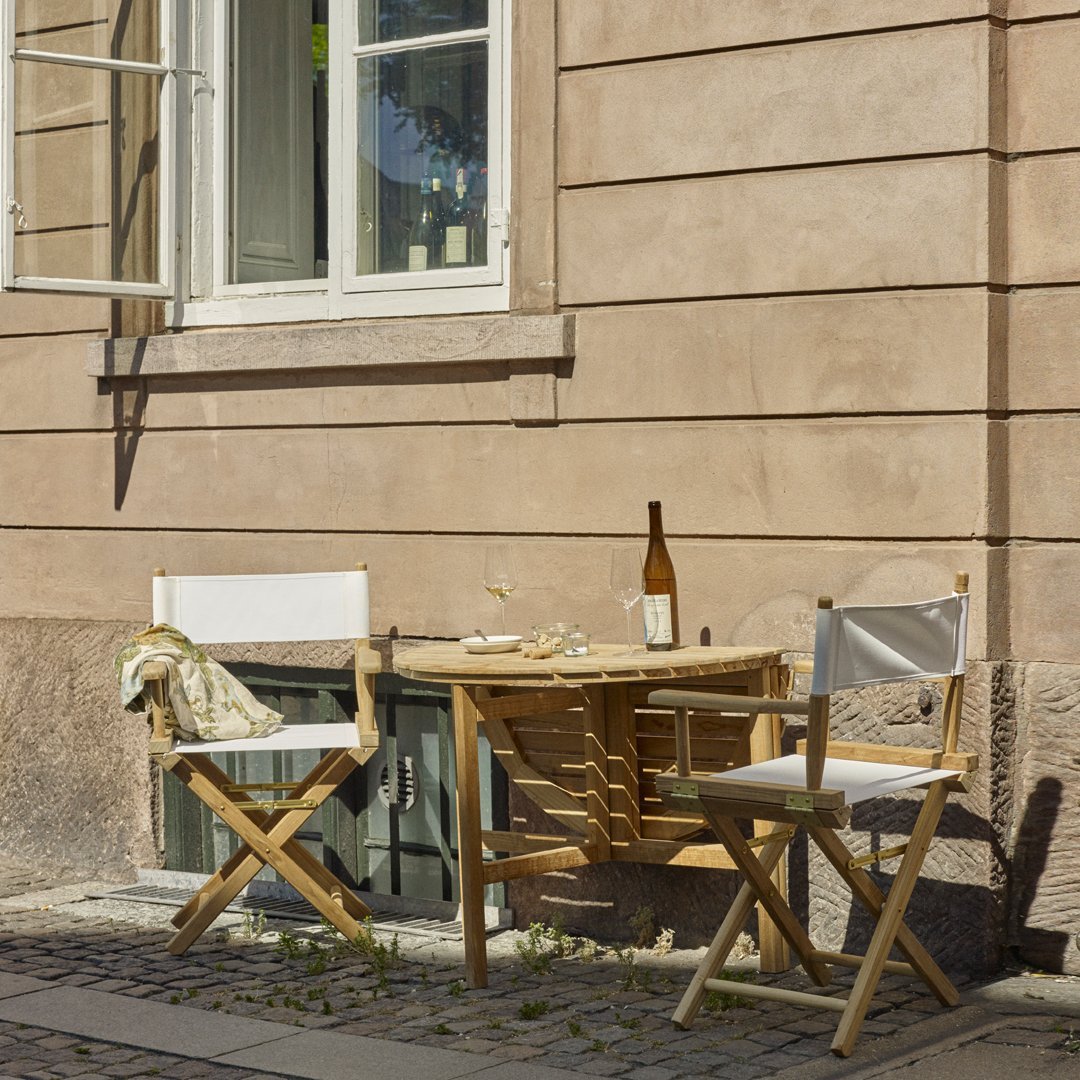 "Light wood dining set with white cushions against a soft beige wall, featuring a minimalistic and modern design."