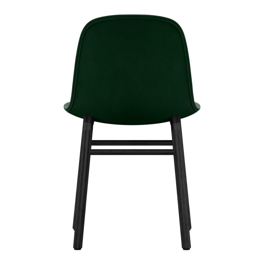 "Back view of a green upholstered chair with a black wooden frame, showcasing a sleek, modern design."