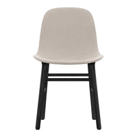 Soft beige chair with a smooth upholstered seat and contrasting black wooden legs, minimalist design.