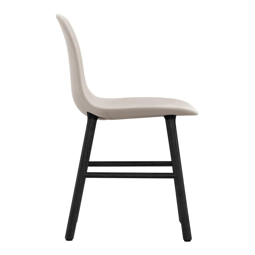 Modern chair in soft beige with sleek black wooden legs, featuring a minimalist design and smooth contours.