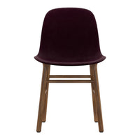 Burgundy velvet chair with wooden legs, featuring a sleek, modern design and minimalistic style. Perfect for any decor.