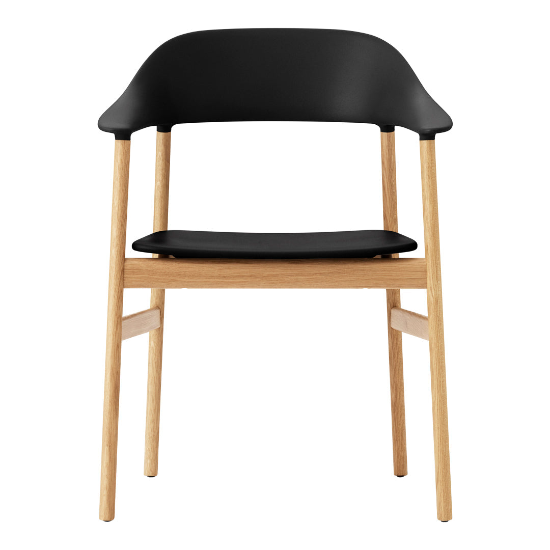 Black chair with a smooth matte finish and light natural wooden legs, showcasing a sleek, modern design.