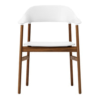 White chair with smooth curves and wooden legs, showcasing a minimalist design and neutral color palette.