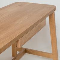 Light wood table with smooth, natural grain and rounded edges, featuring a simple, minimalist design.