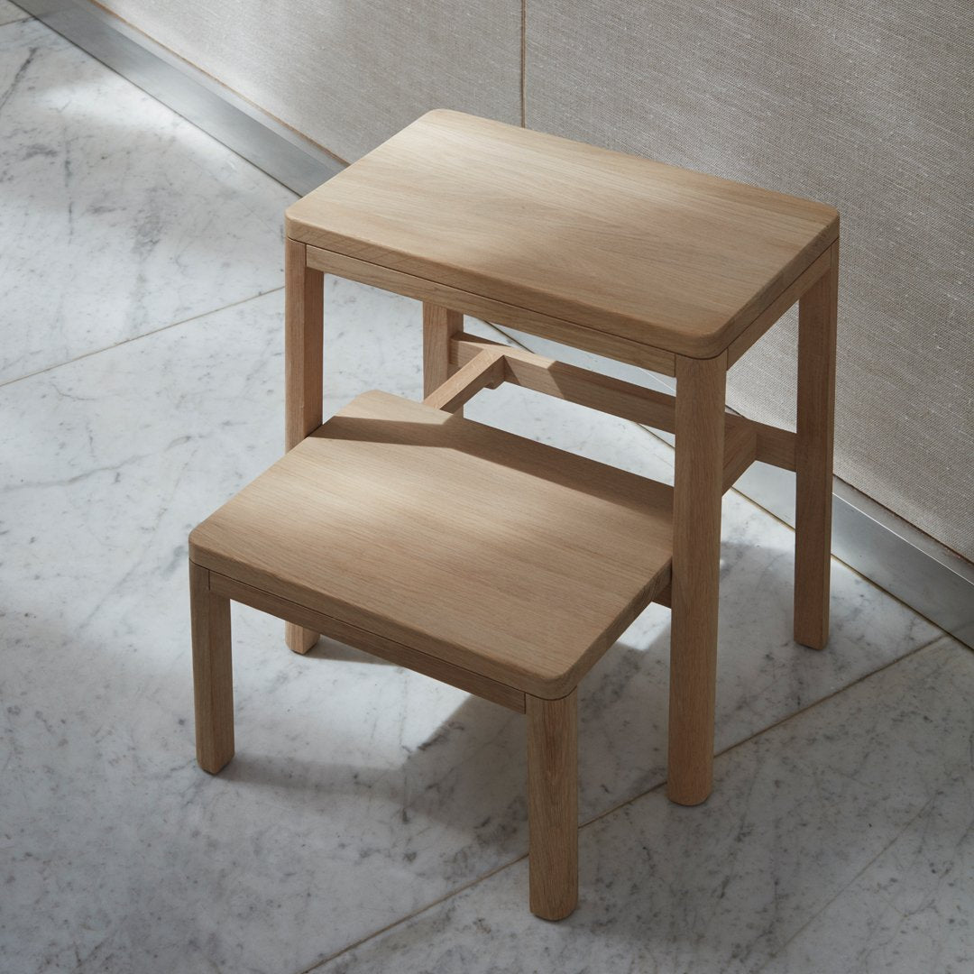 Natural wood finish step stool with a sleek, minimalist design and smooth surface. Perfect for any interior.