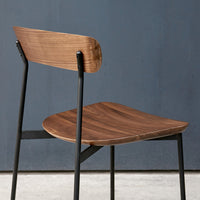 Modern chair with a sleek walnut wood seat, contrasting black metal legs, and a smooth, minimalist design.