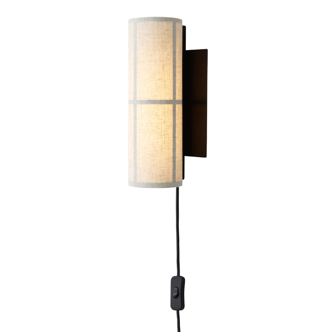 Sleek cylindrical wall lamp in cream with black grid pattern and brown wall mount, featuring a pull switch.