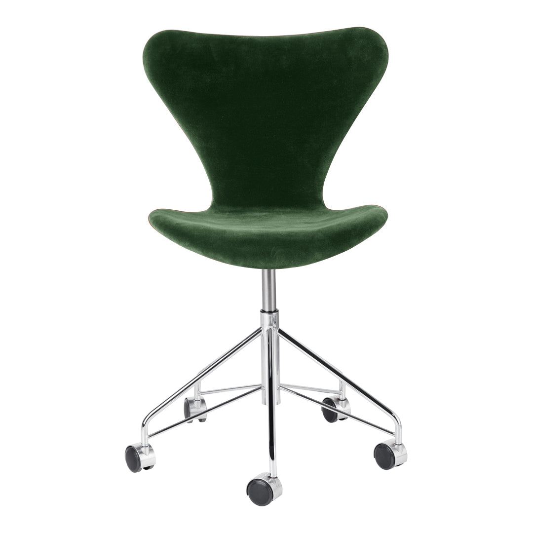 Green velvet swivel chair with a sleek chrome base and smooth lines, perfect for modern decor.