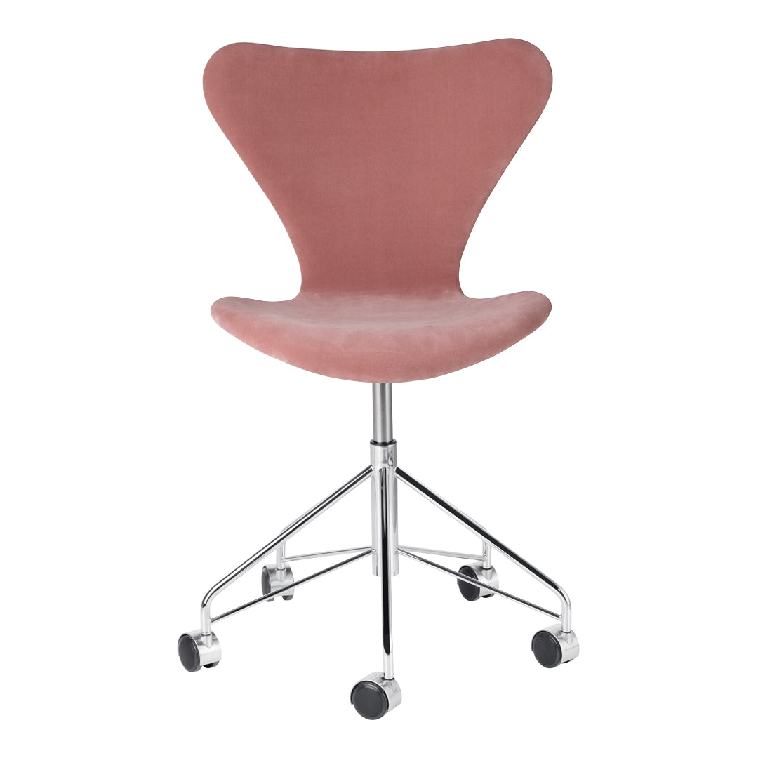 Pink velvet chair with a sleek curved design, featuring a chrome base and rolling wheels for easy mobility.