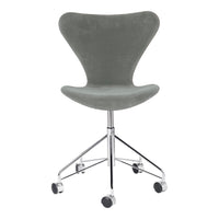 Gray upholstered chair with a smooth texture, supported by a sleek chrome base, featuring wheels for easy mobility.