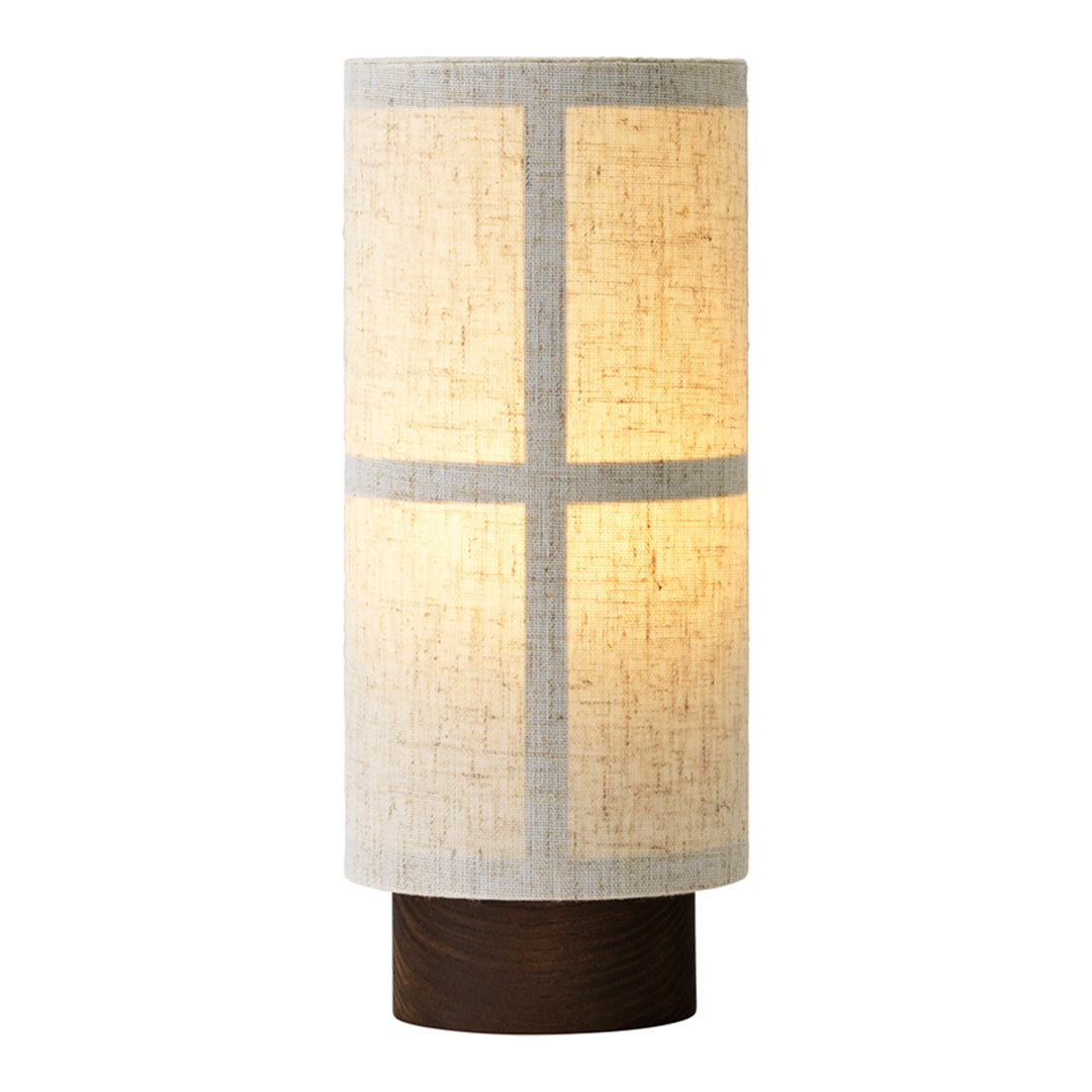 Neutral beige and white lamp shade with a simple grid pattern, wooden base, and warm yellow light glow.