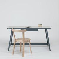 Scandinavian-style desk and chair in soft gray and natural wood tones, with simple, clean lines.