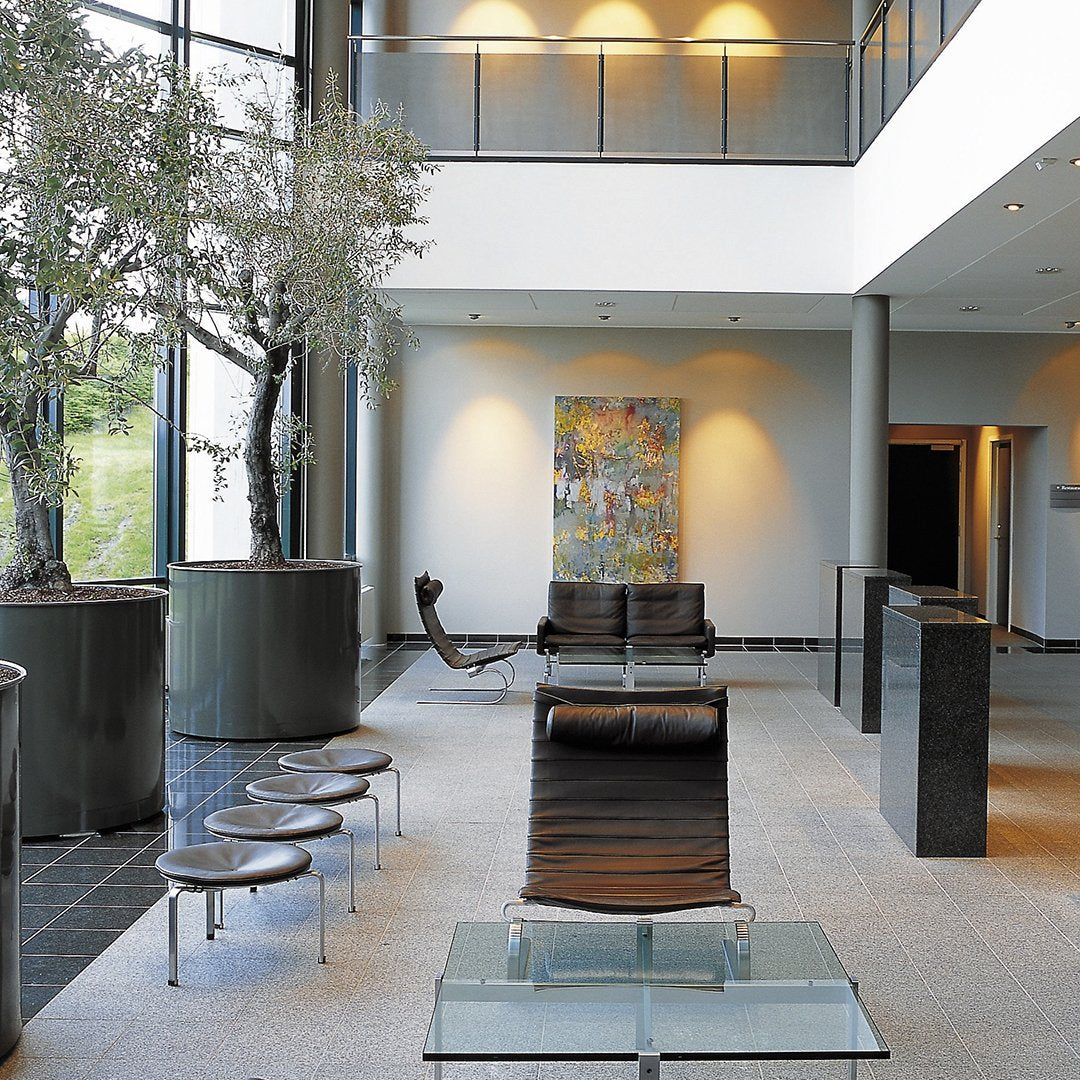 Modern lobby featuring neutral tones, abstract colorful artwork, and sleek black and glass furniture.