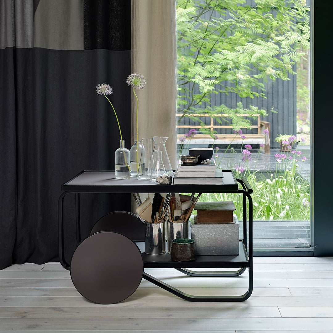 Modern black and gray patterned side table with sleek lines and circular accents, set in a bright natural backdrop.