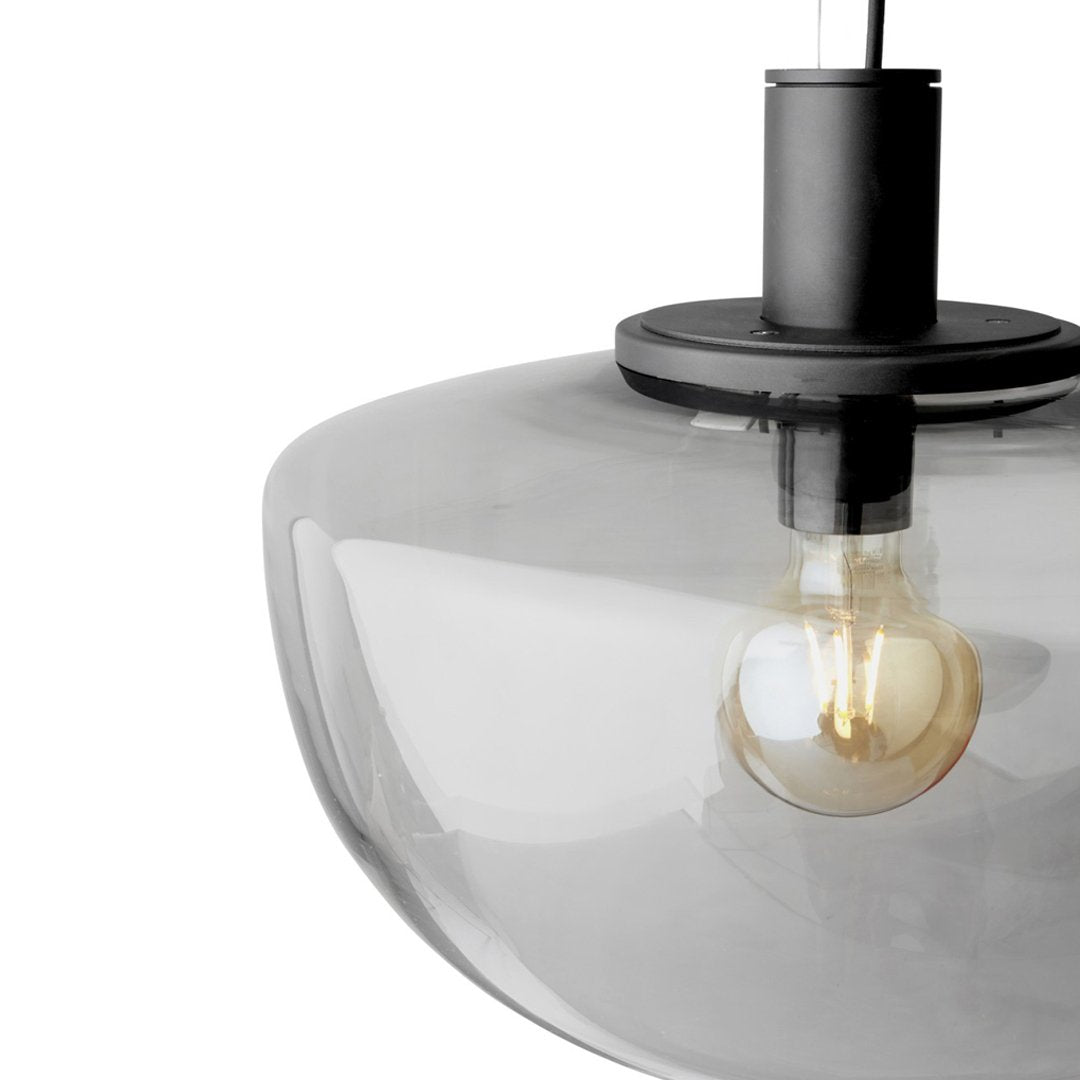 Modern grey glass pendant lamp with a sleek black fixture and warm glowing bulb. Perfect for contemporary decor.