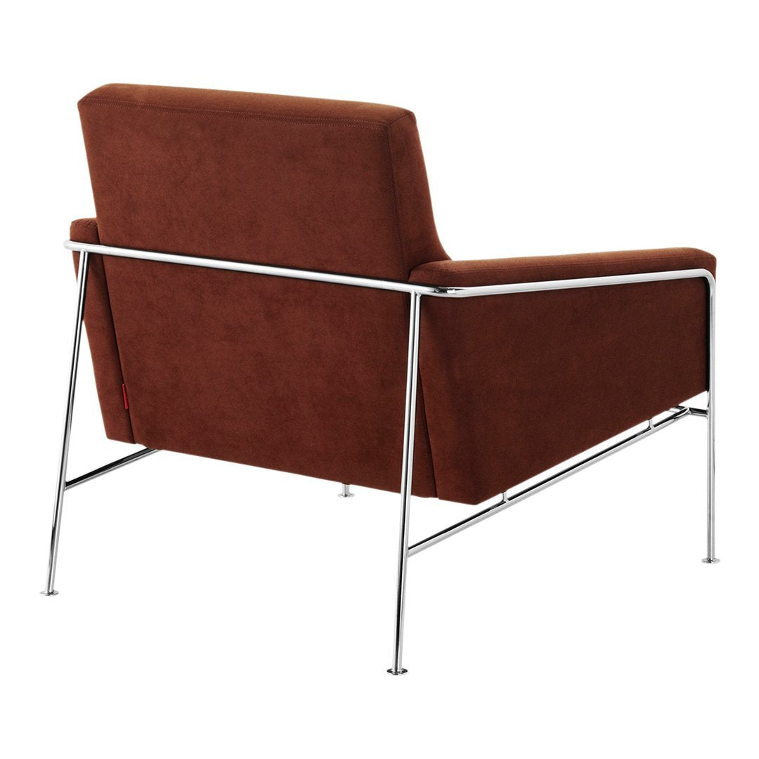 Brown upholstered armchair with a sleek chrome frame, showcasing a minimalist design and soft texture.