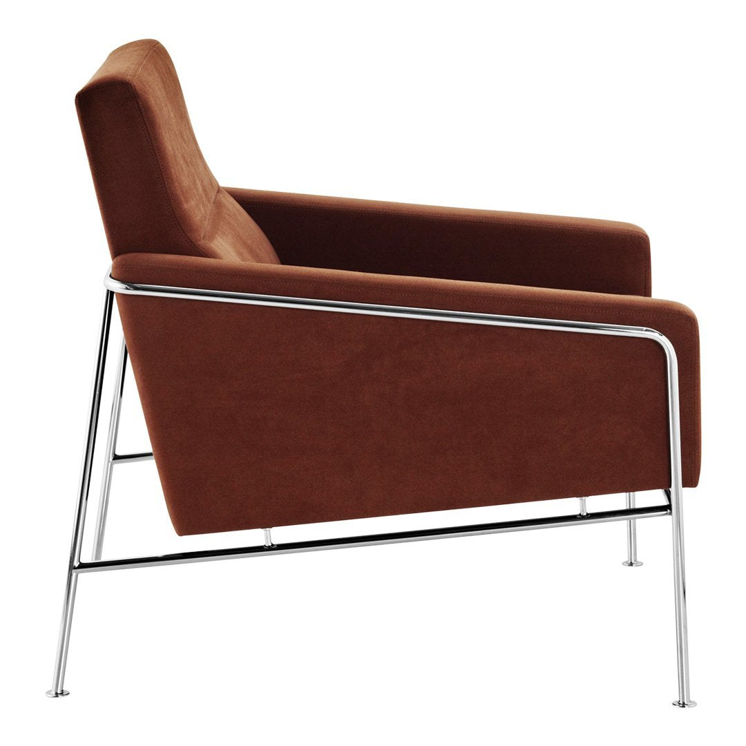 Brown upholstered armchair with sleek chrome legs, showcasing a modern minimalist design.