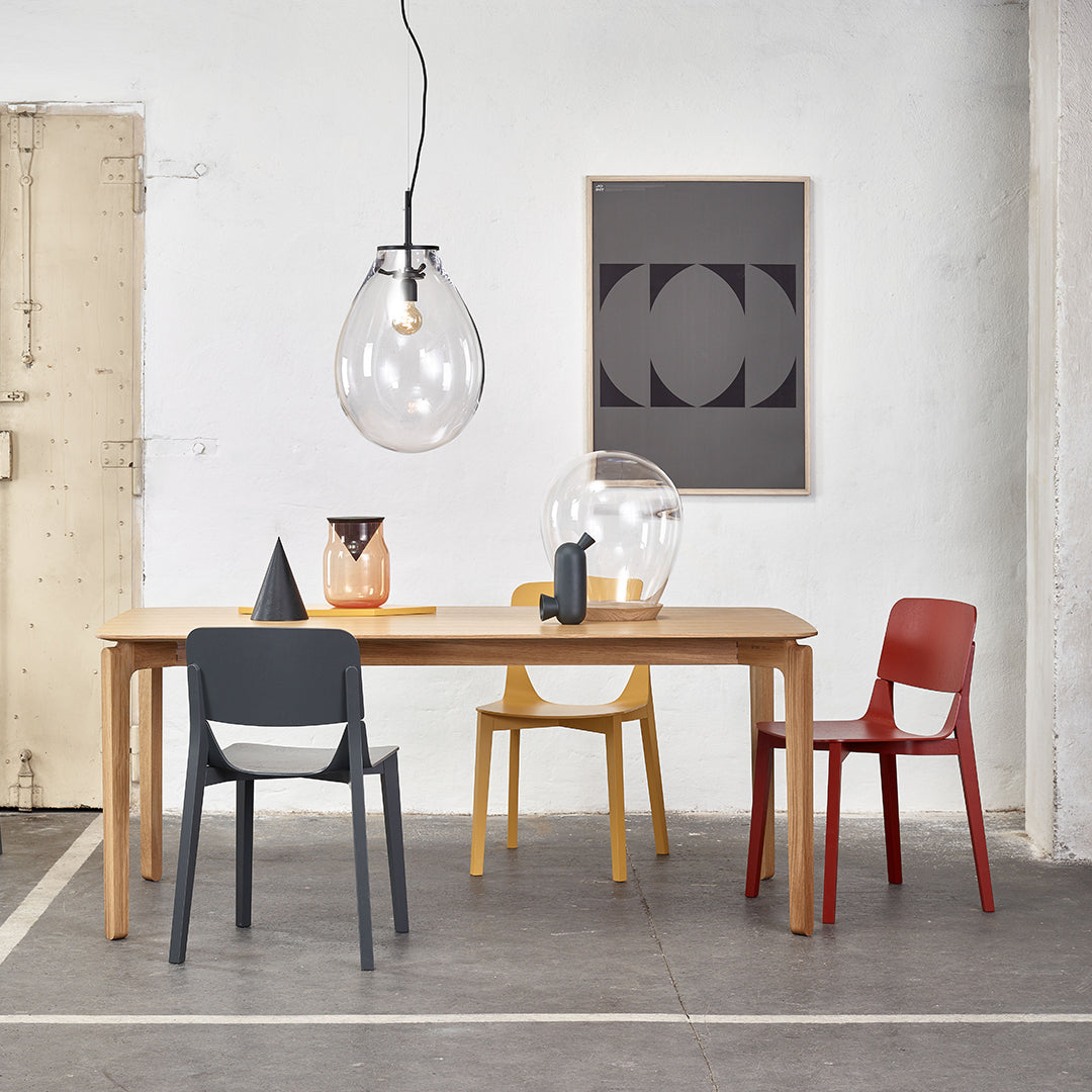 Modern dining scene with gray, red, yellow, and clear glass accents, featuring a mix of geometric patterns.