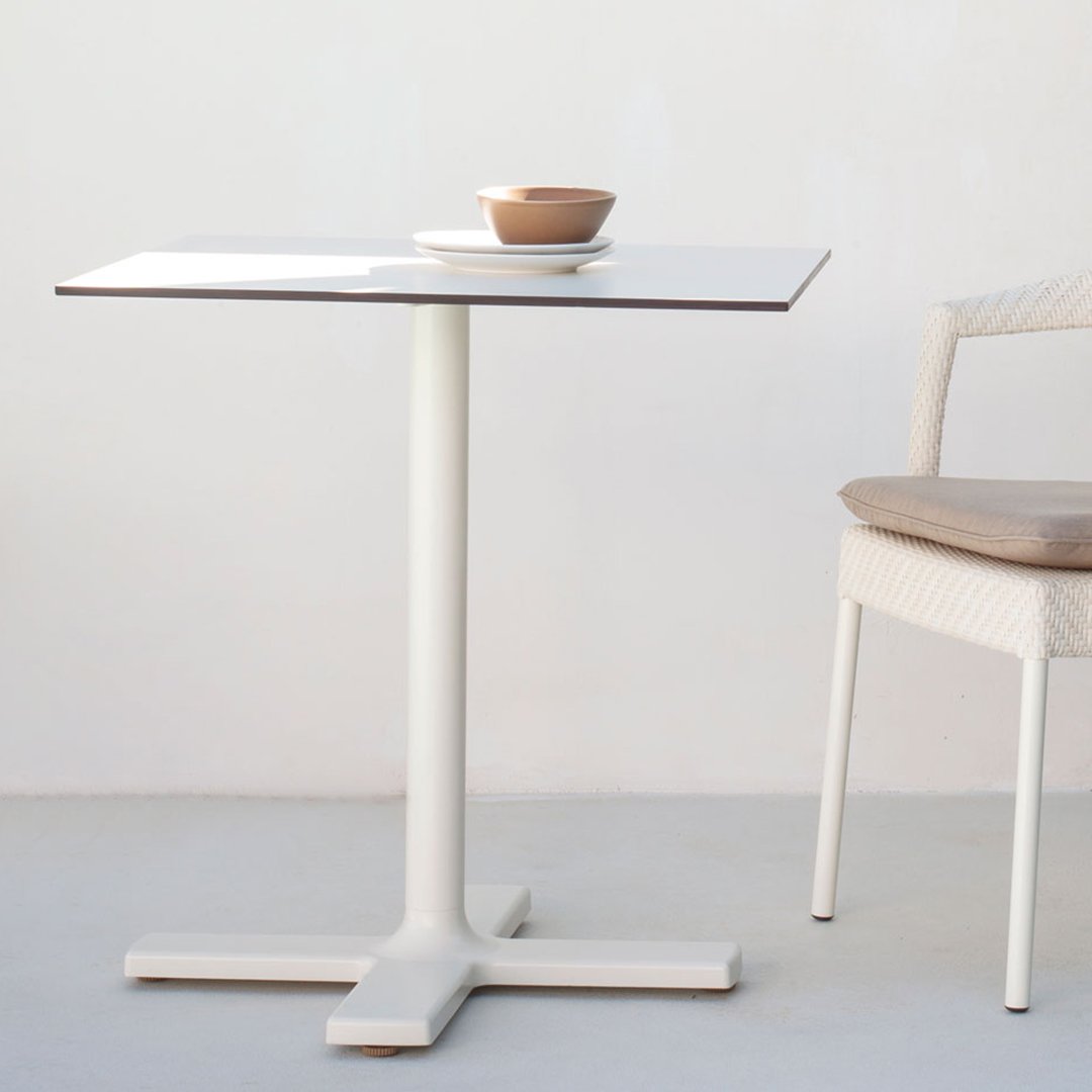 White tabletop with a minimalist design, featuring a light gray base and a soft beige chair with a woven seat.