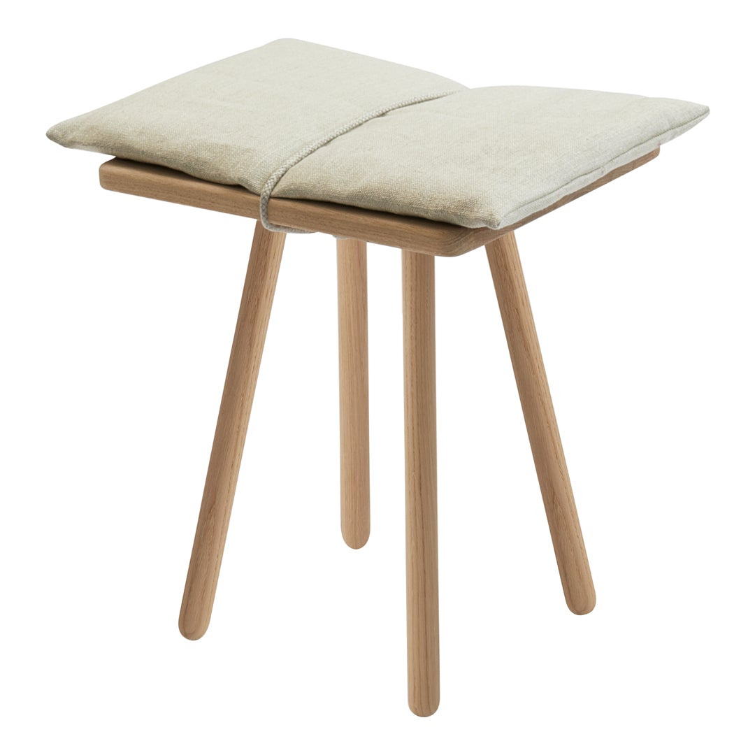 Light beige cushion atop a natural wood stool with simple, clean lines and a minimalist design.