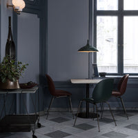 Elegant dining space featuring deep blue walls, gray checkered floor, and rich burgundy and green chair accents.