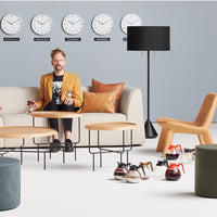 Modern living room featuring gray walls, tan sofa, brown accent pillows, and colorful decor elements in a minimalistic style.