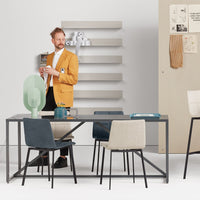 Modern dining room featuring a yellow jacket, gray chairs, beige tones, and a minimalist backdrop with clean lines.