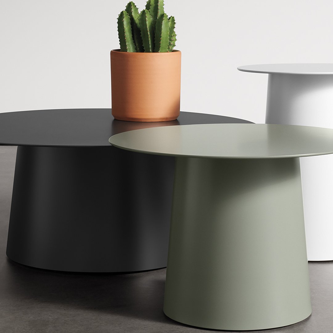 Three modern side tables in matte black, olive green, and white, accompanied by a terracotta planter with a cactus.