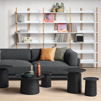 Stylish black accent tables with a textured finish, paired with a dark gray sofa and colorful decorative cushions.