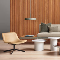 Modern living room featuring warm wood tones, neutral beige, soft green cushions, and sleek white tables.