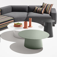 "Modern coffee tables in green, white, and black with contrasting striped cushions in vibrant colors."