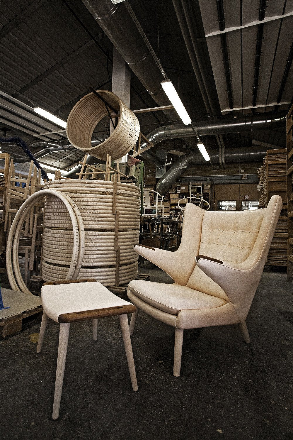 Cream upholstered armchair and matching light wood side table in a workshop setting, featuring neutral tones and simple patterns.