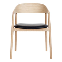 Light oak wood chair with a sleek black leather seat, featuring a minimalist design and natural finish.