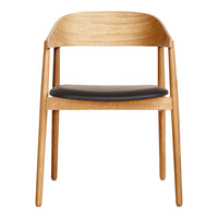 Wooden chair with a light oak finish and sleek black leather seat, highlighting a minimalist design.