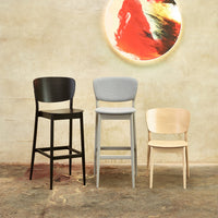 Three stylish bar stools in black, light gray, and natural wood finish against a textured beige background.