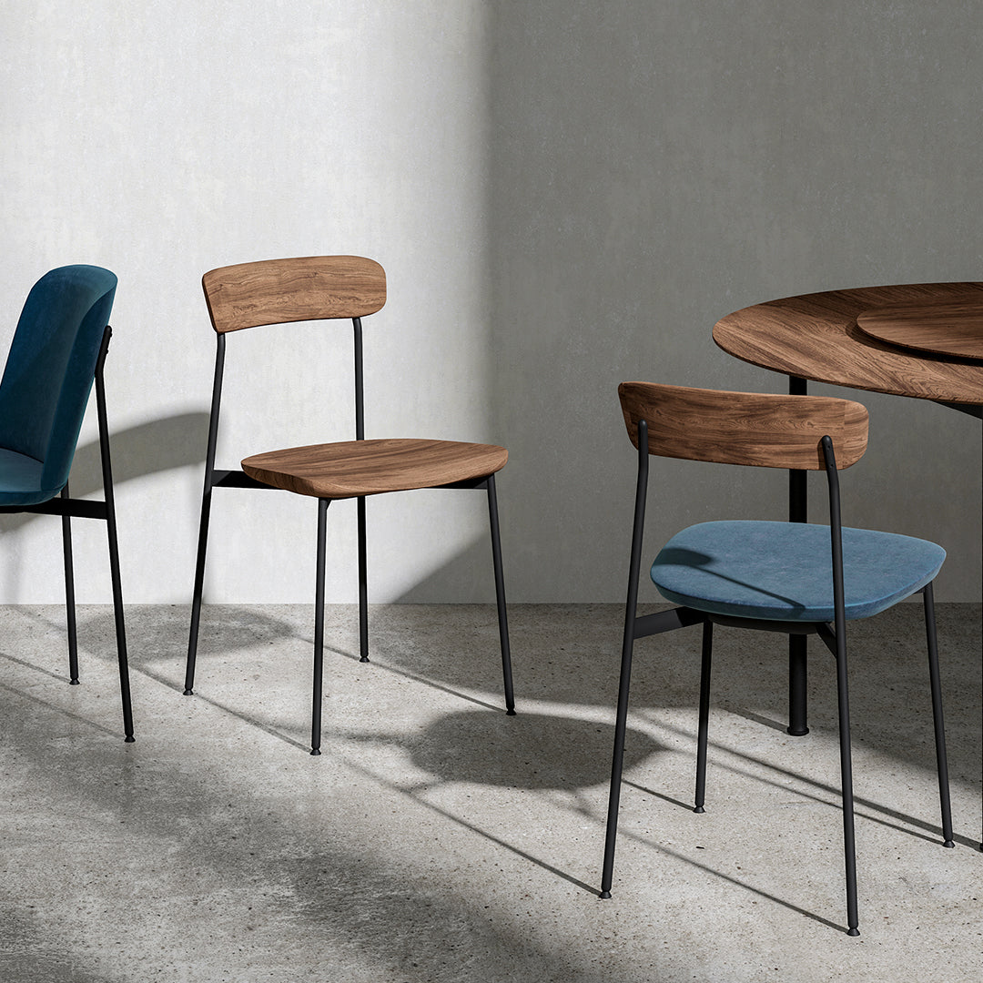 Wood and metal chairs in muted blue and brown tones, featuring sleek lines and modern design against a concrete background.