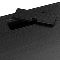 Close-up of a sleek black textured surface with a subtle wood grain pattern and a cut-out handle design.