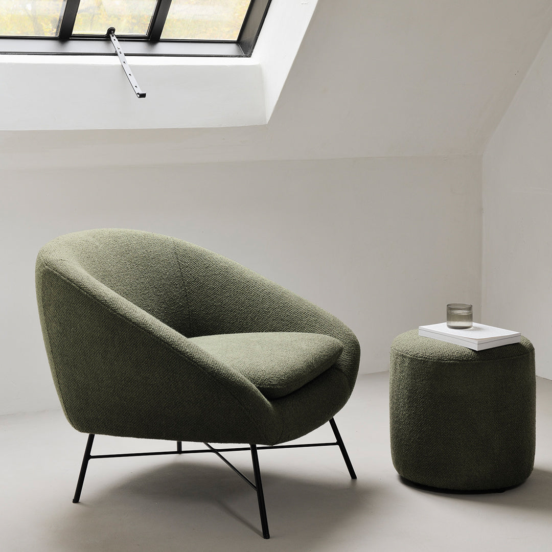 Green upholstered chair with a matching ottoman, featuring a textured finish and modern black metal legs.