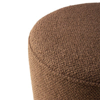 Round brown ottoman with textured, woven fabric for a stylish, modern look. Perfect for any living space.