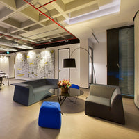 Contemporary lounge featuring blue and gray seating with sleek lines, complemented by a black lamp and modern decor.