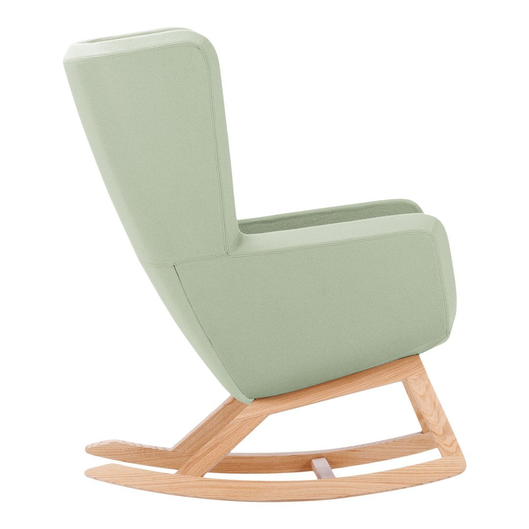 Light green rocking chair with a smooth, minimalist design and natural wood base. Perfect for modern decor.