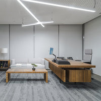 Modern office with gray walls, wooden furniture, and a minimalist design featuring sleek lines and soft textures.